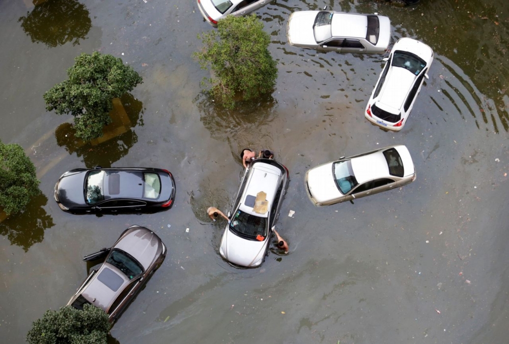 中國南方省份近日飽受洪災之苦，2016年7月中國湖北省武漢市連日暴雨，導致居民的車淹沒水中。（湯森路透）