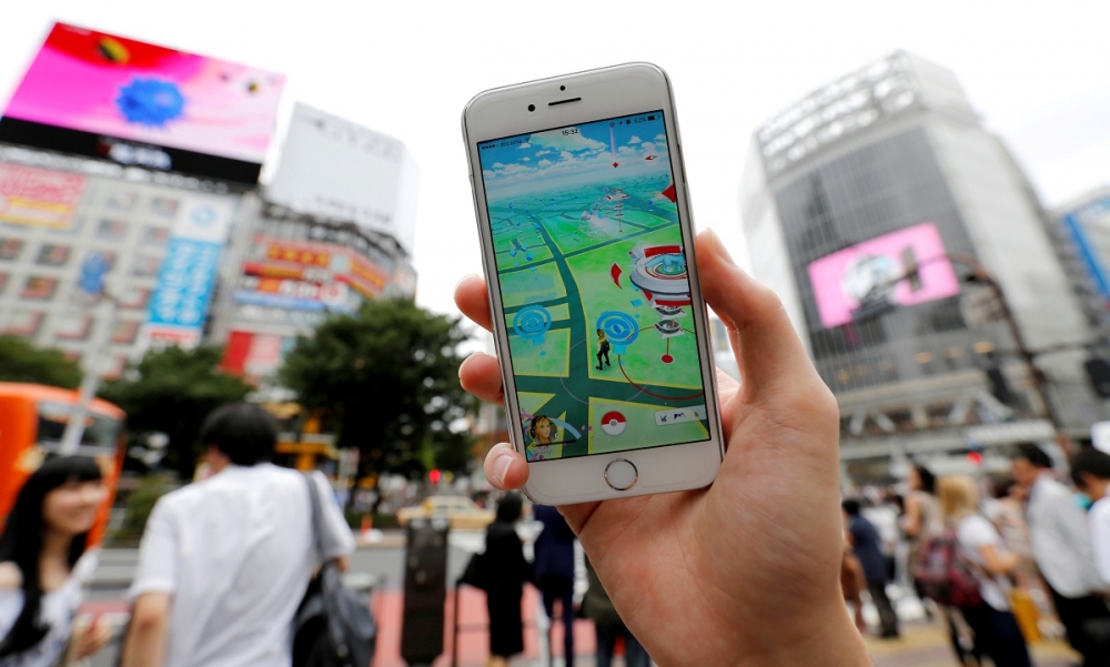 一名玩家在日本東京涉谷街頭玩《Pokémon GO》。（湯森路透）