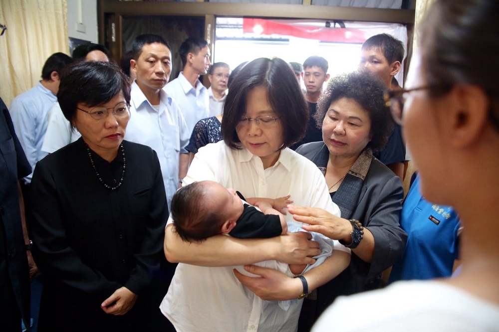 蔡英文抱著陳世坤才兩個月大的孩子，表情難過不捨。（高雄市政府提供）