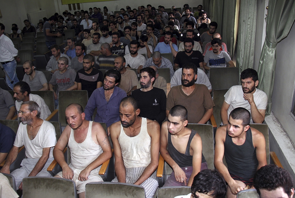 敘利亞囚犯坐在大馬士革的法庭裡面等待釋放。（美聯社）