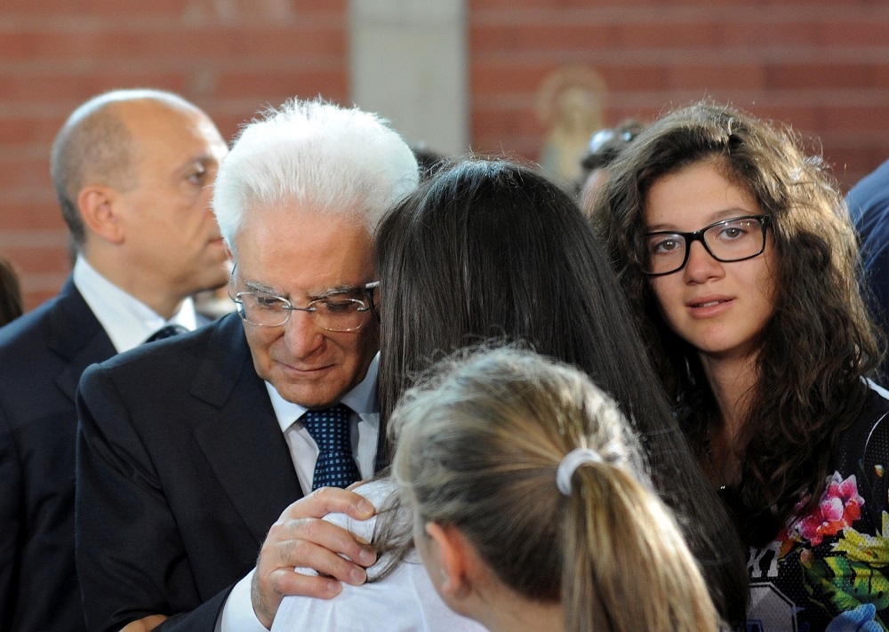 義大利總統馬達雷拉（Sergio Mattarella）在葬禮上傾聽一名女士的心聲。（湯森路透）