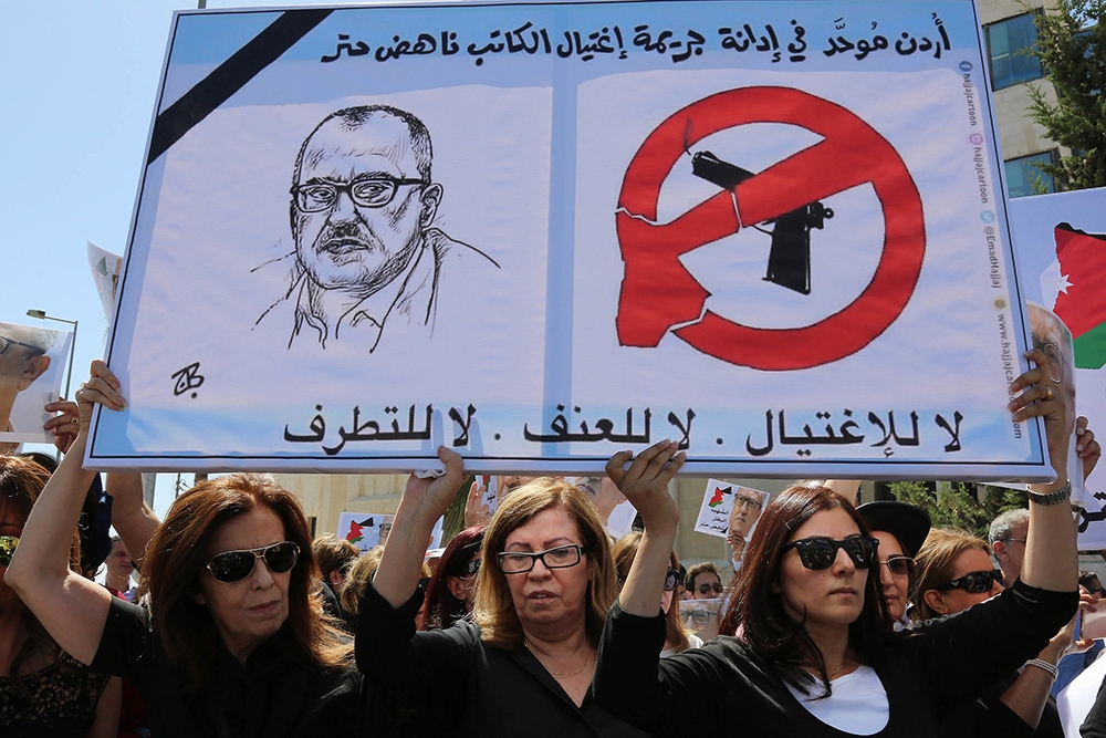 作家哈塔爾的親人在約旦總理府前抗議。（美聯社）