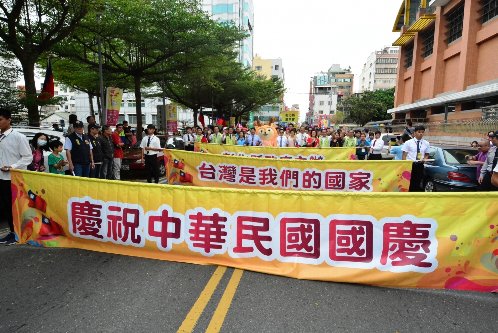 彰化縣10日舉辦國慶遊行，除了現場學生樂隊演出外，行進間舉的標語「台灣是我們的國家」意外成焦點。（彰化縣政府提供）