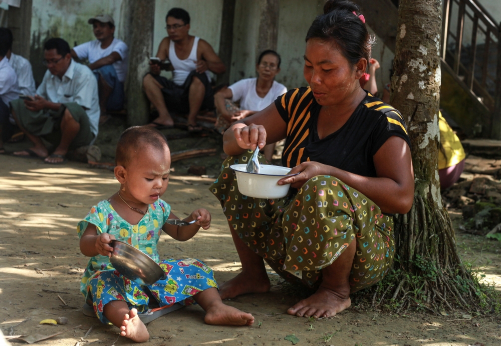 一名羅興亞婦女在緬甸境內的安置區餵食孩子。（湯森路透）