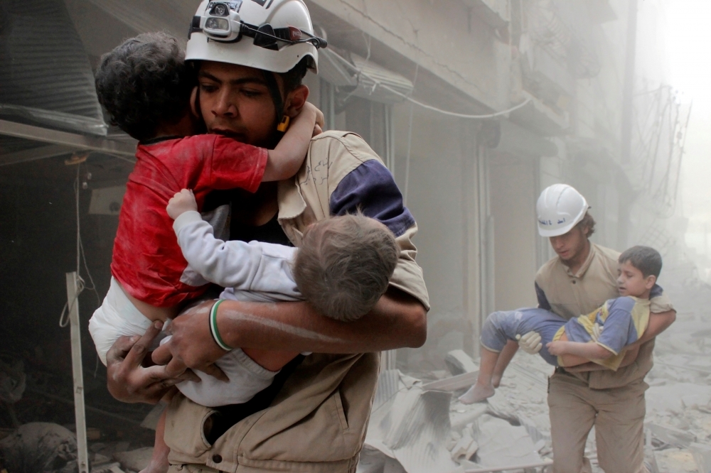 救難員搶救遭炸彈空襲的小孩，反政府活躍人士指稱該場空襲為支持敘利亞總統阿塞德（ Bashar al -Assad）的軍隊所發動。（湯森路透）