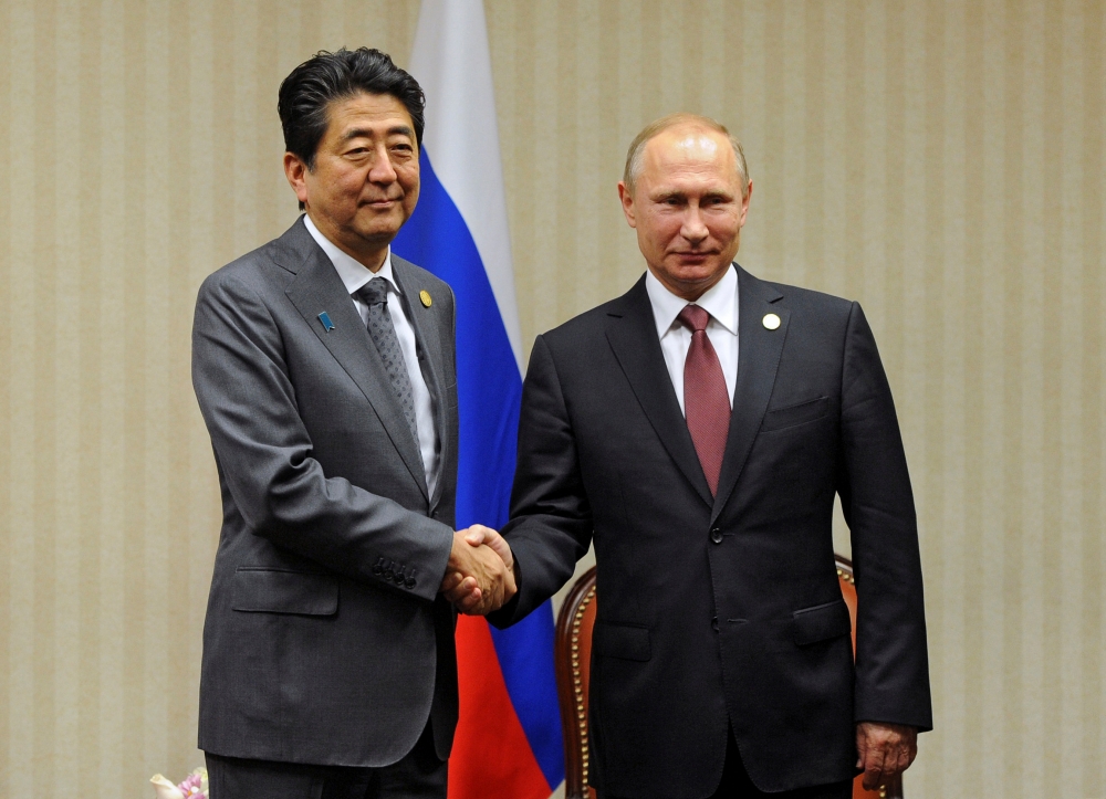 安倍晉三與普京在11月在APEC峰會上握手。（湯森路透）