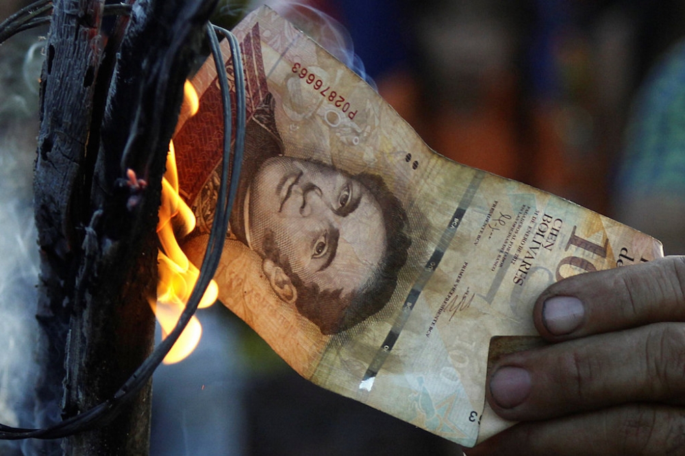 憤怒的委內瑞拉人民開始焚燒已失效的100玻利瓦紙鈔。（湯森路透）