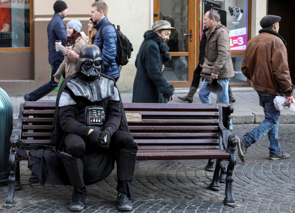 一名打扮為黑武士「達斯維達」的男子坐在烏克蘭街上。（湯森路透）