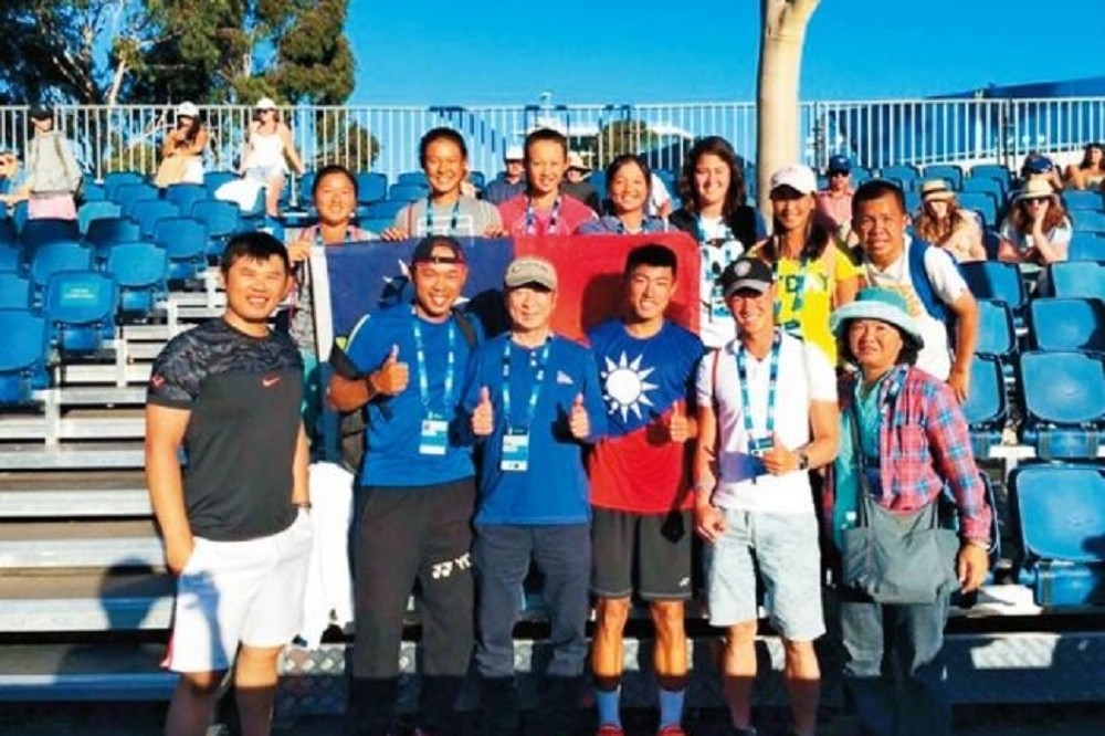 我國新秀許育修（右三）澳網青少男雙奪冠後，成為第4個在澳網青少年組男雙獲得冠軍的台灣男子球員，他於賽後開心穿上國旗裝與教練、親友合影。（教練張孝雍提供）