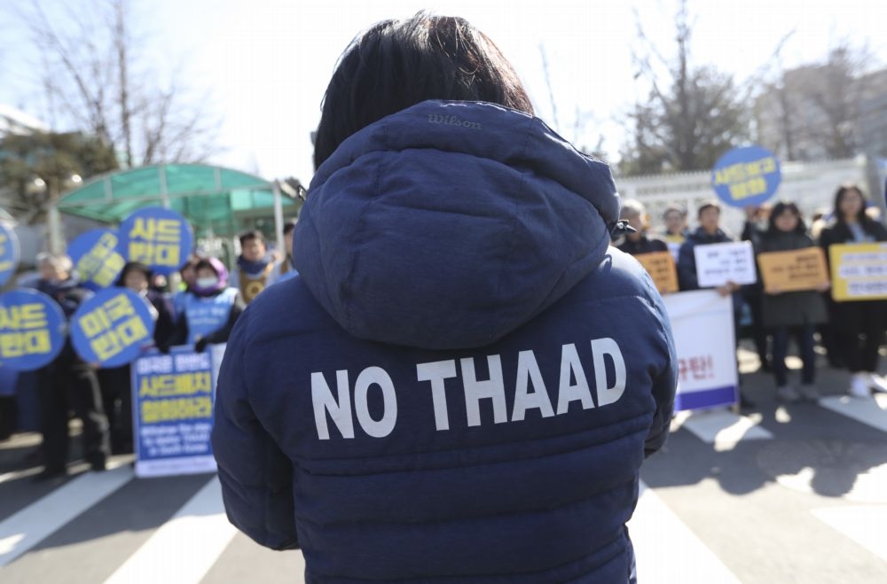 7日，南韓首爾1名穿著反THAAD字樣外套的抗議者。（美聯社）