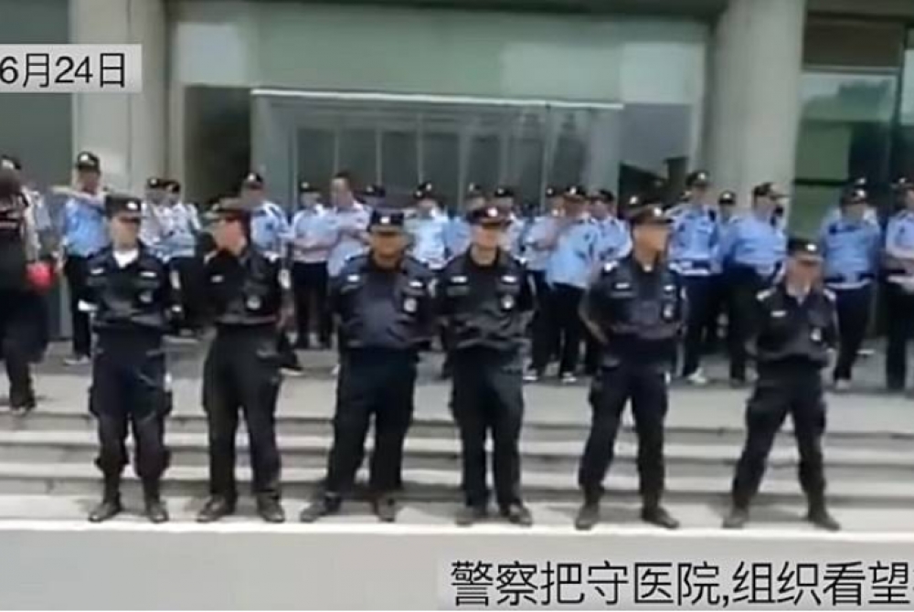 6月24日，中國武警在鎮江第一醫院前站崗，防止退役軍人入內。（取自影片）