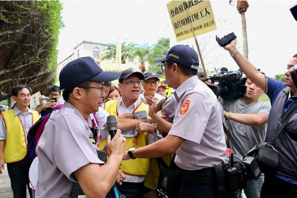 台灣美光晶圓公司企業工會、佳福育樂公司企業工會等工會21日至總統官邸前抗議，遭警員抵制。（攝影：張凱婷）