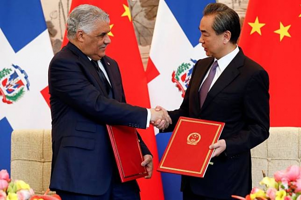 中國外長王毅（右）今與多明尼加外長巴爾加斯（左）於北京簽署建交公報。（湯森路透）