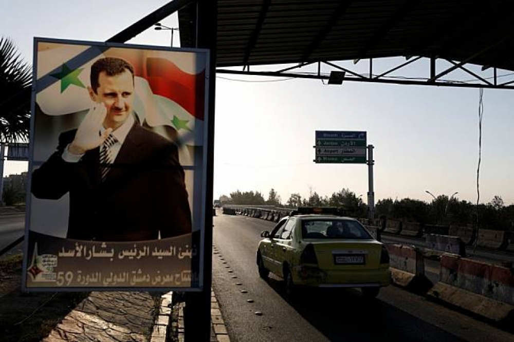 敘利亞高速公路旁圖片為阿塞德的看板。（湯森路透）