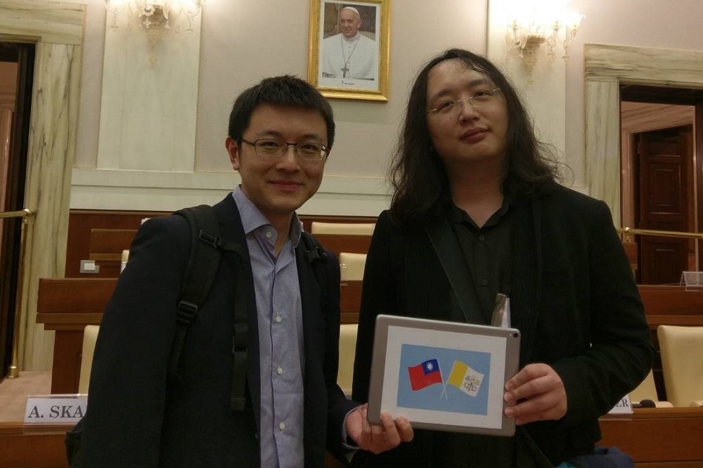 唐鳳（右）10日應邀前往梵蒂岡參加一場由教廷主辦的科技研討會，而她演講時手持的iPad上頭，背面貼著台灣與梵蒂岡國旗。（唐鳳辦公室提供）
