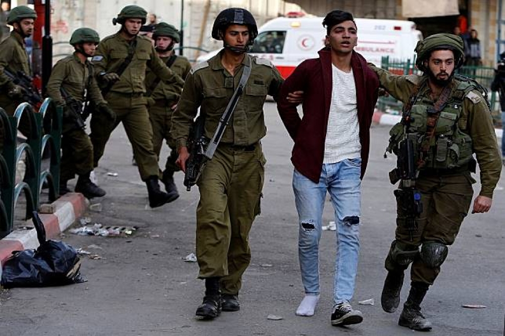 以色列警方10日在約旦河西岸城市希伯侖（Hebron）逮捕一名巴勒斯坦示威青年。（湯森路透）
