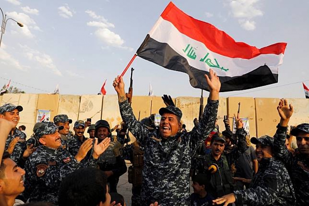 伊拉克軍人7月自IS手中收復摩蘇爾後開心慶祝。（湯森路透）