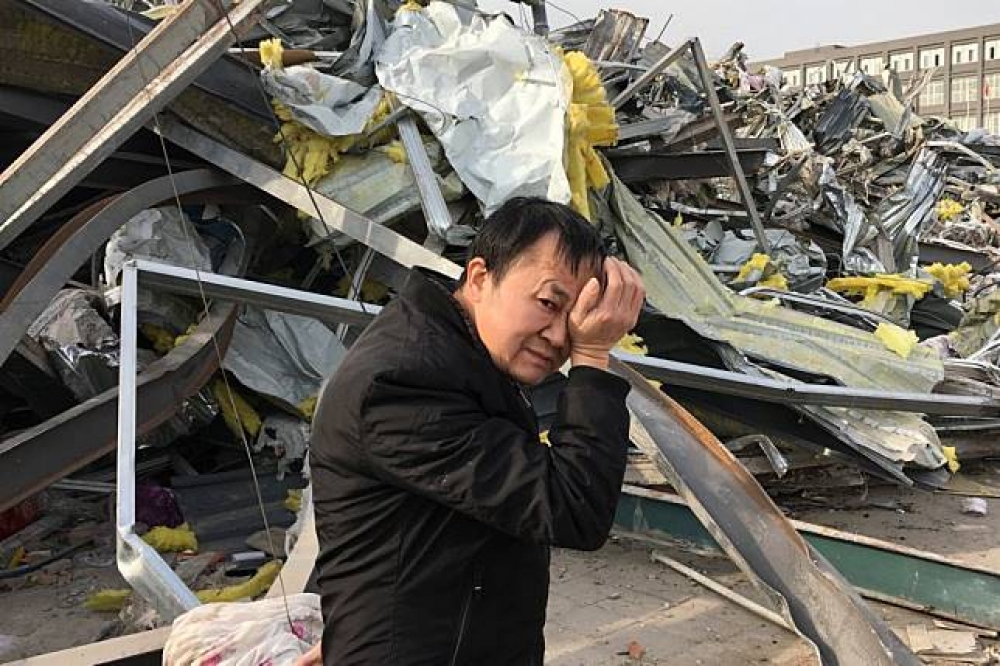 中國北京遭驅趕的低端人口拭淚。（湯森路透）