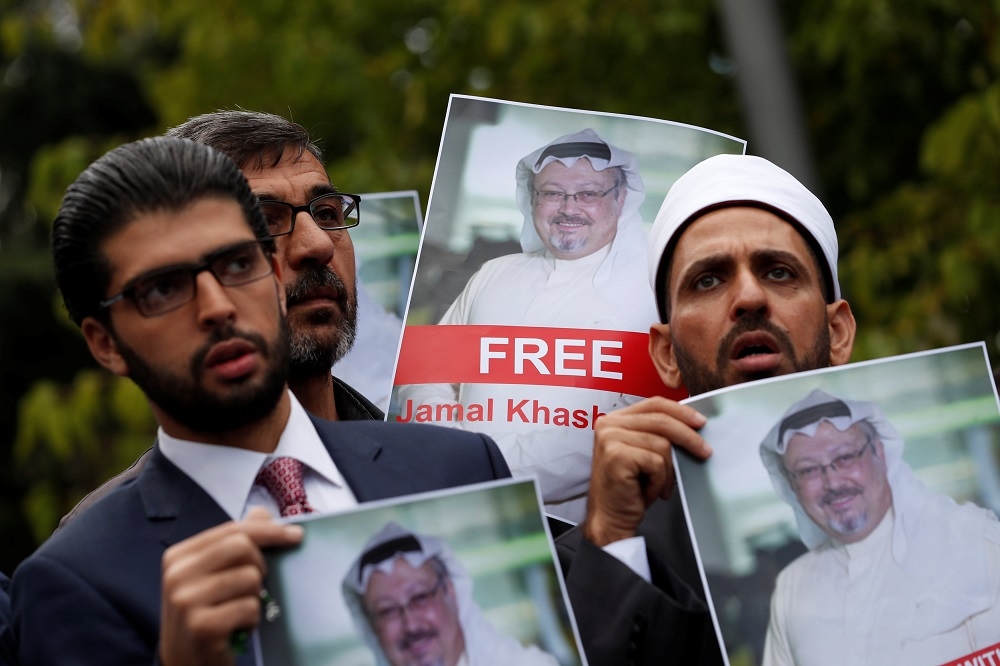 人權團體在沙國駐伊斯坦堡領事館外，手持卡舒吉（Jamal Khashoggi）照片抗議。（湯森路透）
