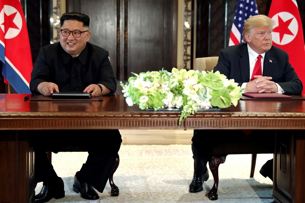 美國總統川普（右）、北韓領導人金正恩（左）在6月12日新加坡舉行的川金會。（湯森路透）