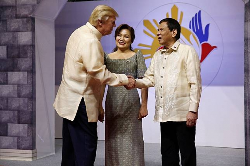 美國總統川普（左）與菲律賓總統杜特蒂（右）握手致意。（湯森路透）