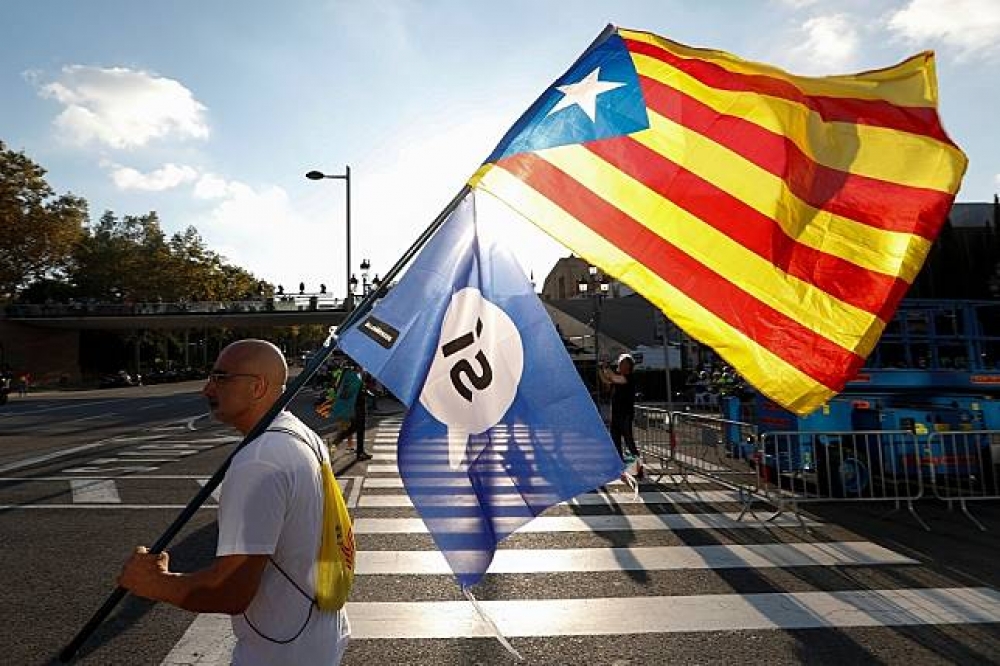 民眾在加泰隆尼亞自治區首府巴塞隆納（Barcelona）拿著自治區旗以及支持公投的旗幟。（湯森路透）