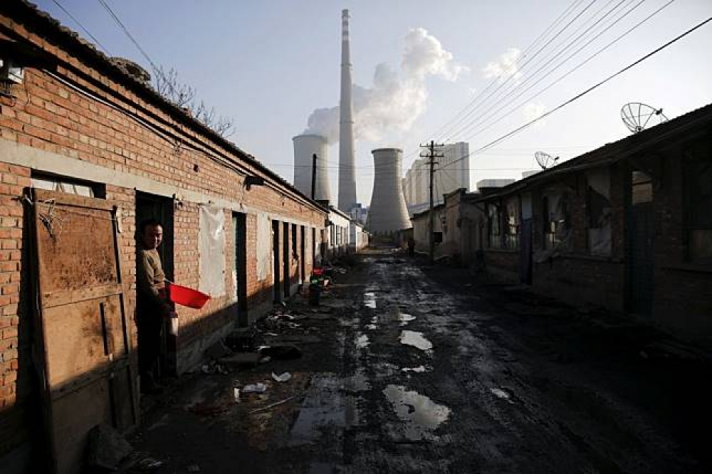 北京市居民住家外的工業區煙囪。（湯森路透）