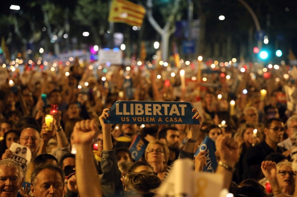 支持獨立的民眾聚集大街，手持燭燈與標語。（美聯社）