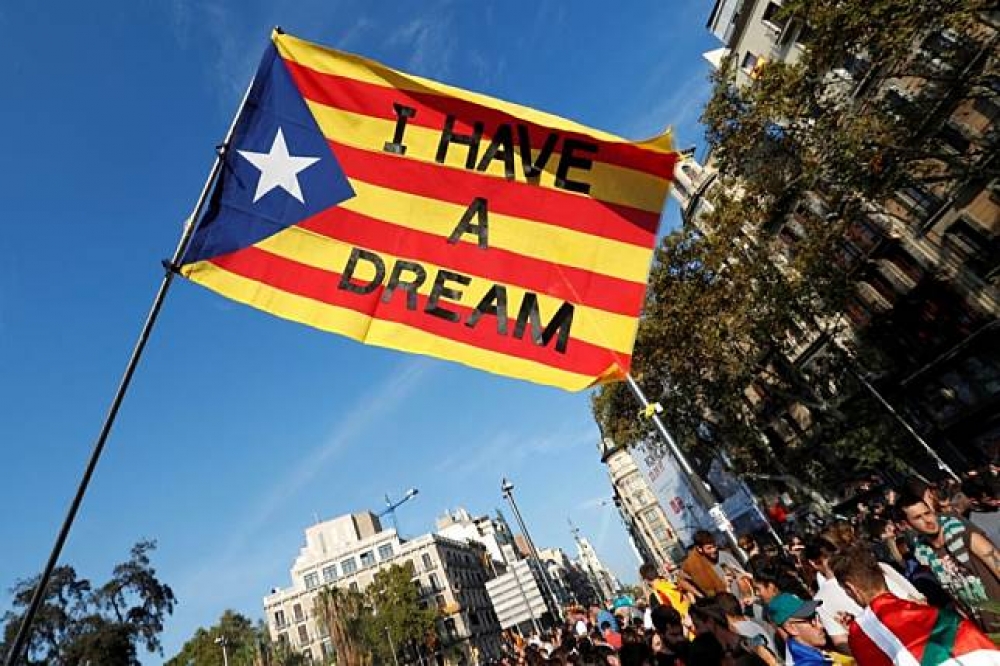 民眾揮舞加泰隆尼亞獨立旗幟，上頭寫著標語「我有個夢」。（湯森路透）