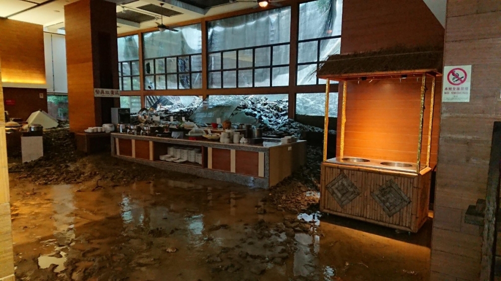 台東知名的富野飯店因緊鄰山坡，14日遭土石流襲擊，泥水夾雜土石灌破一樓餐廳玻璃。（圖片取自爆料公社）