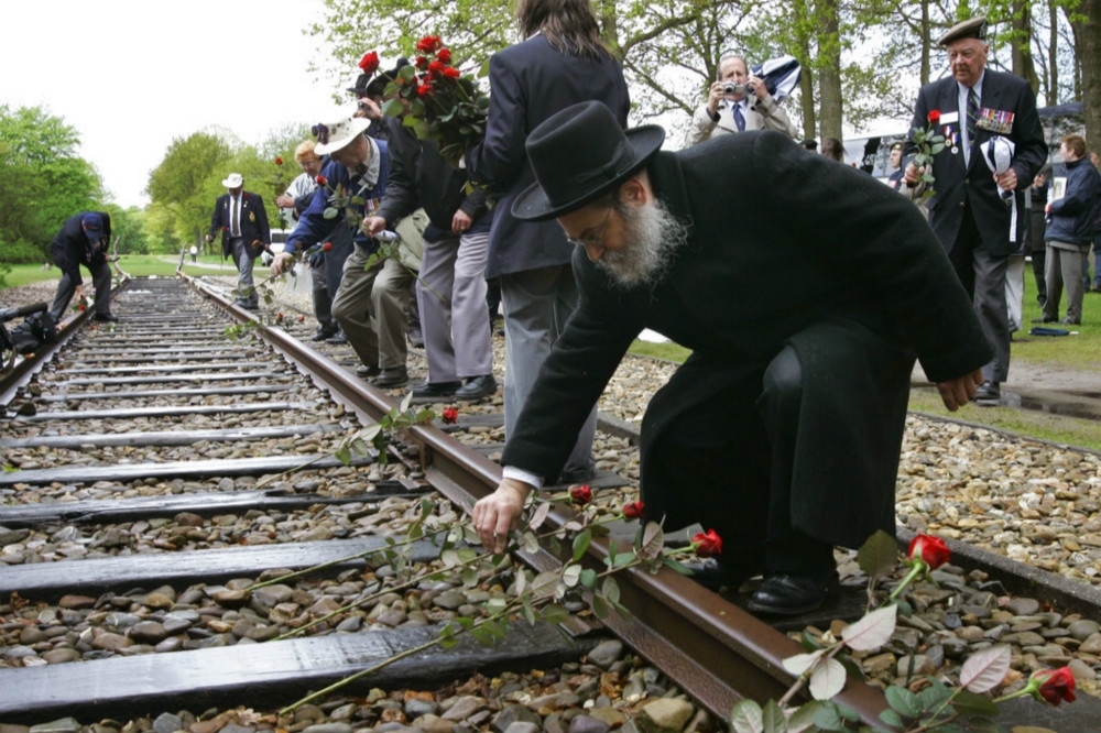 紀念遭納粹以荷蘭鐵路送往死亡營的歷史，猶太後裔在鐵軌放置玫瑰花。（美聯社）