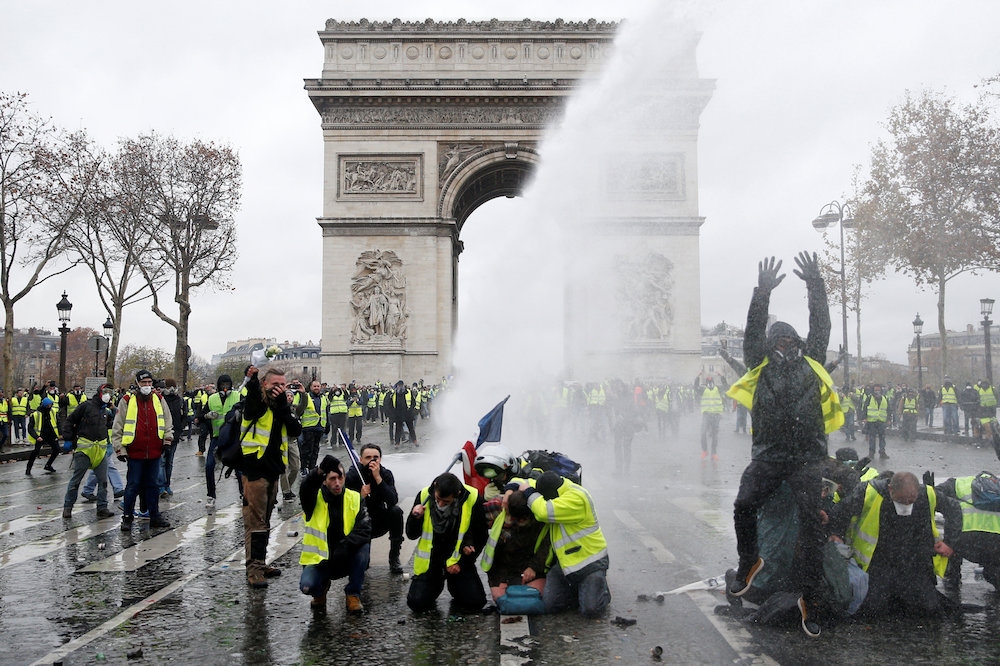 身穿黃背心的民眾在巴黎凱旋門前抗議。（湯森路透）