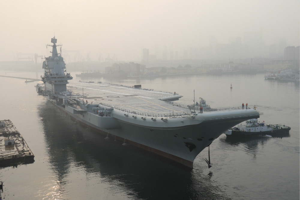 中國第二艘航母從大連造船廠碼頭啟航，赴相關海域執行海上試驗任務。（中新社）