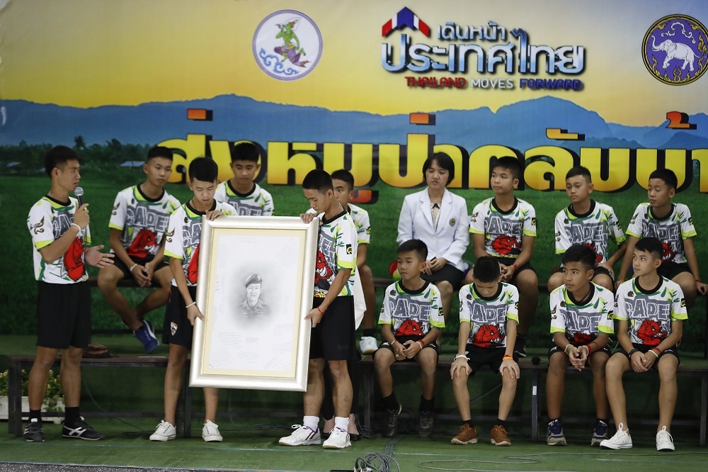 泰國足球少年在記者會上向罹難潛水員沙曼致敬。（美聯社）