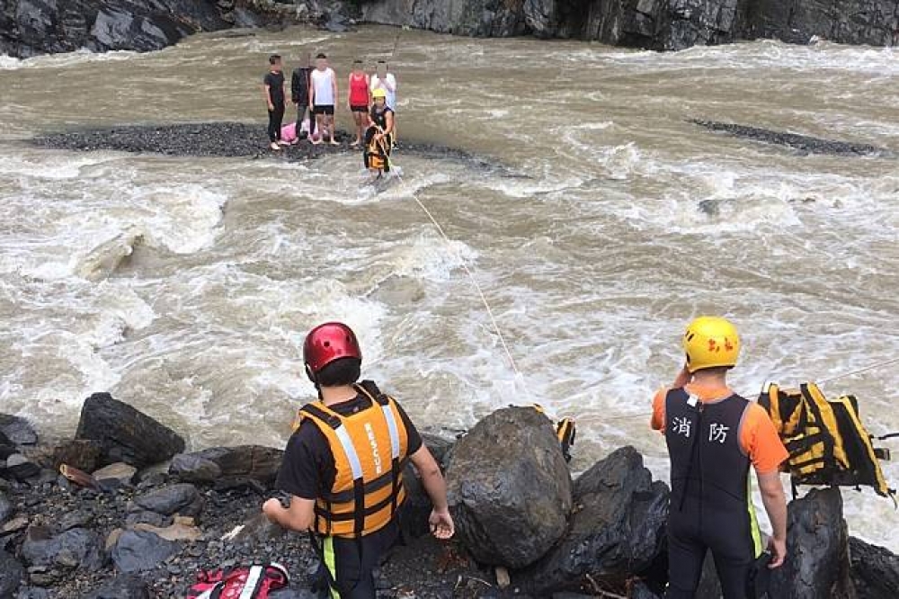 烏來溪水暴漲有5名受困河床，目前順利救出，無外傷不需送醫。（新北市消防局提供）