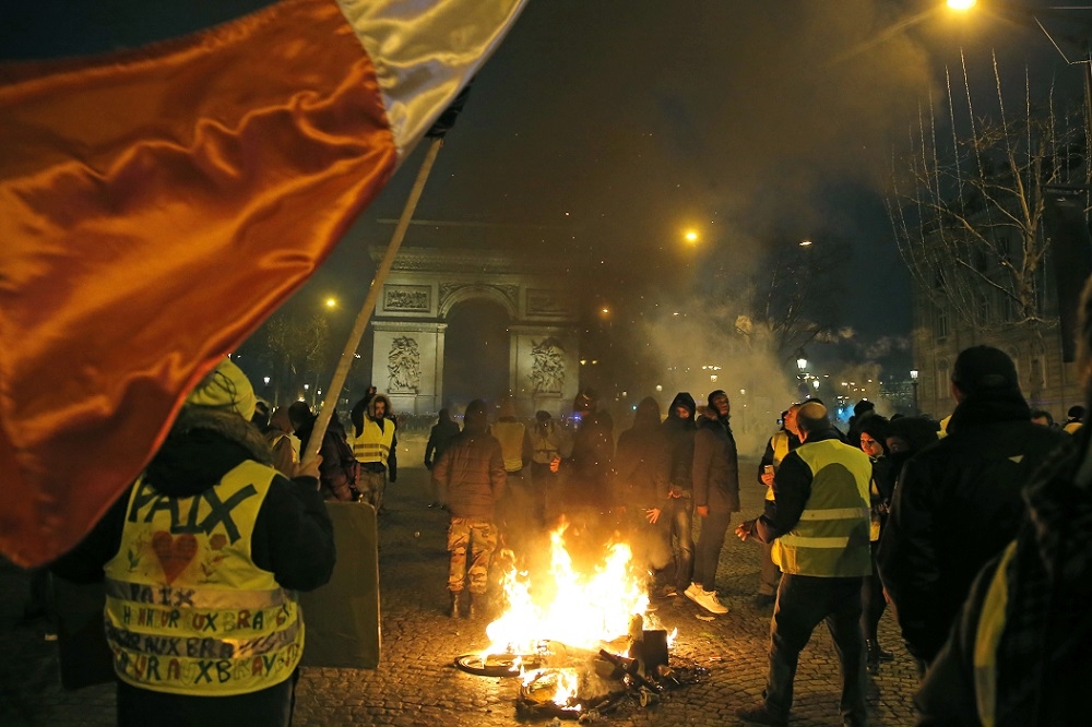 法國黃背心示威民眾5日上街抗議、燃燒路障，表達對政府的不滿。（美聯社）