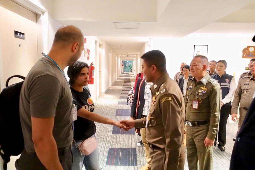 奎農（左二）在聯合國難民署人員陪同下向泰國官員致謝。（湯森路透）
