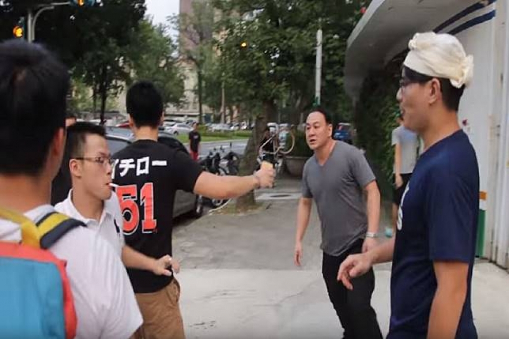 台大學生抗議校方出借田徑場給中國選秀節目，沒想到活動結束後，白狼之子張瑋（右二灰衣男）率人到校外與學生發生衝突。（圖片取自Youtube）
