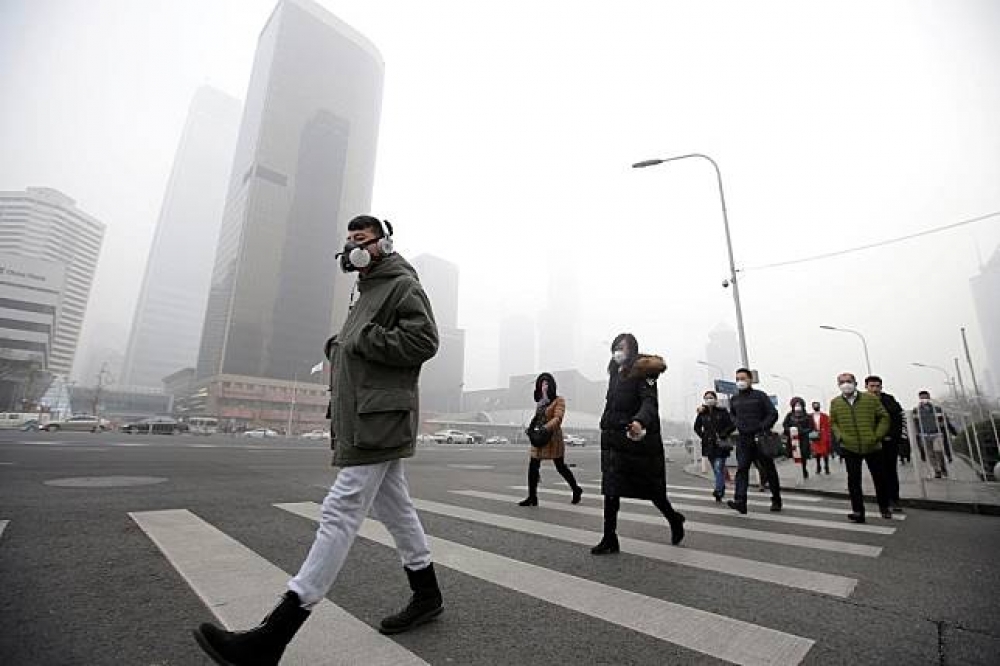 冬季為中國北京的霧霾高峰期，許多民眾選擇戴上口罩。（湯森路透）