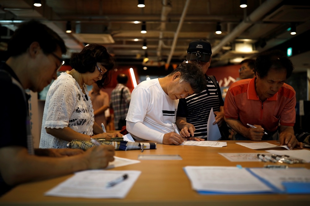 南韓民眾於首爾填寫就職表格。（湯森路透）