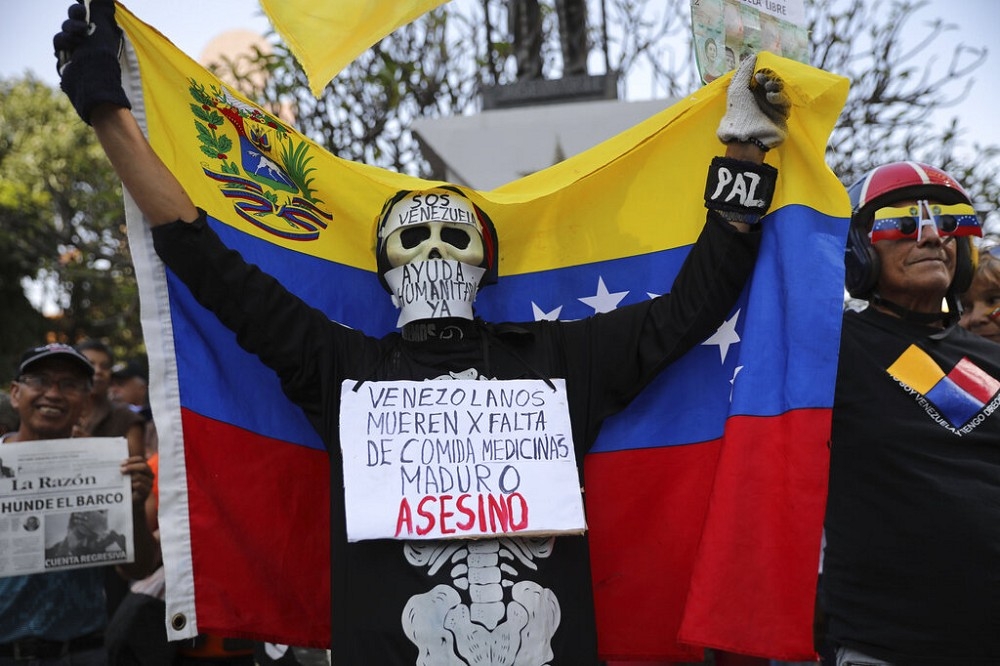 2日民眾要求人道主義援助，並展示「委內瑞拉人因缺乏藥物而死亡。馬杜羅是一名刺客」的標語。（美聯社）