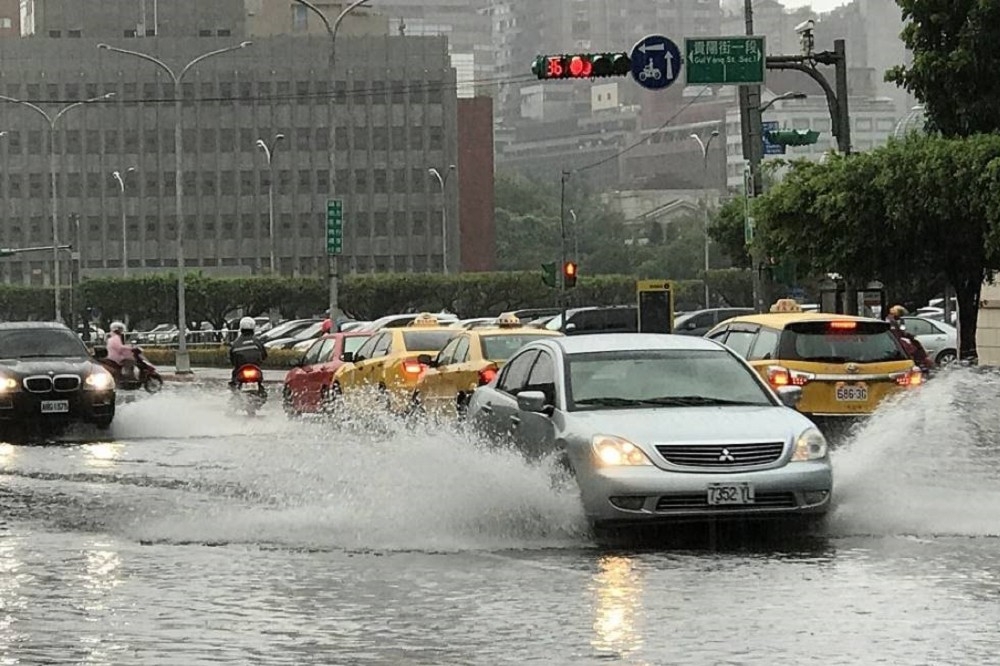 北北基2日下午突降下豪雨、雷聲大作。台北市、新北市與桃園市等部分地區一級淹水警戒。台北市重慶南路、貴陽街口也頓時陷入淹水困境中，車輛經過濺起水花。（攝影：盧禮賓）