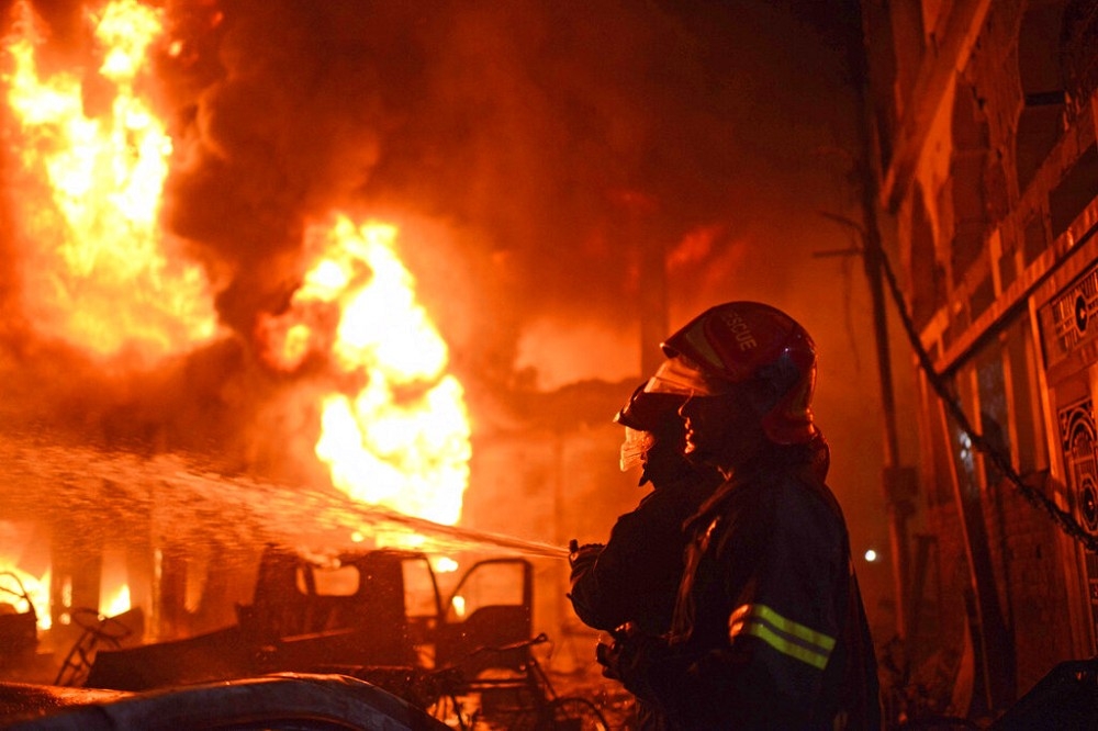 孟加拉首都達卡的舊城區20日發生大火，消防隊前往救援。（美聯社）