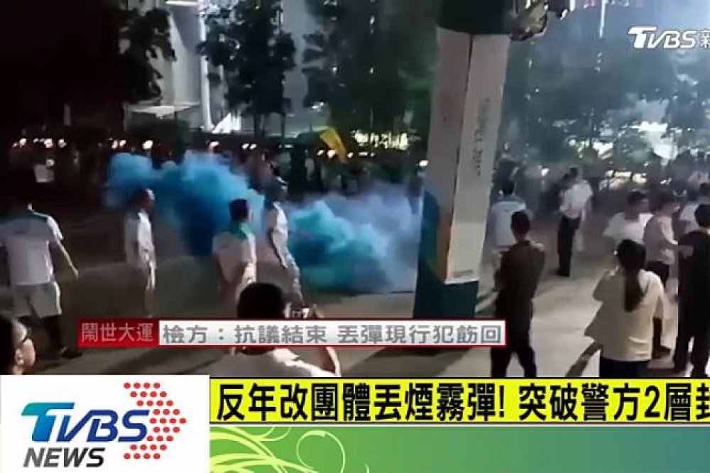 涉嫌世大運開幕日丟擲煙霧罐滋事男子陳進添，上午遭警方拘提到案。（圖片取自TVBS新聞台）