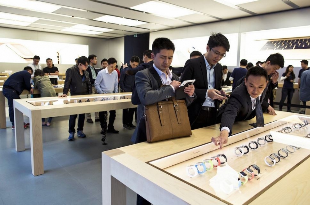 香港民眾正在觀看展示櫃內的Apple Watch。（湯森路透）