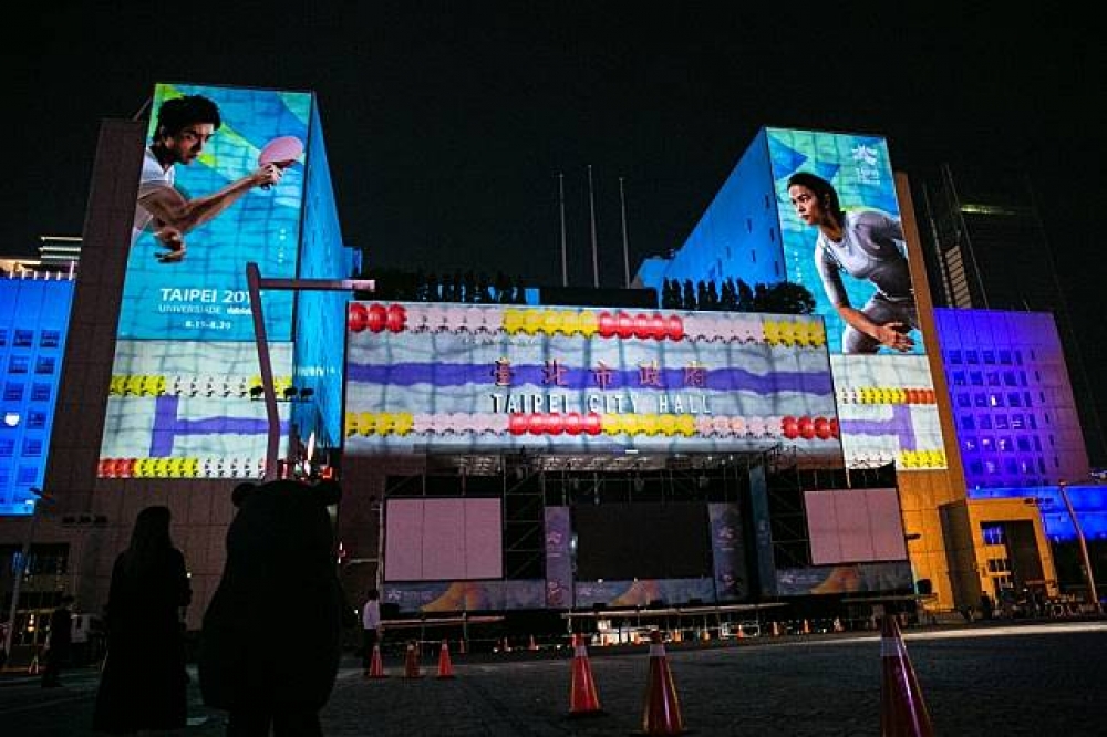 為了吸引民眾目光，台北市政府特別打造令人驚豔的3D光雕秀，也呼應一旁懸掛在市府大樓上的世大運宣傳大使江宏傑、許淑淨兩人圖像。（攝影：陳育陞）