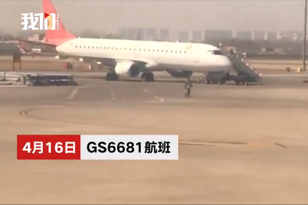 中國一名女性乘客為了祈福朝天津航空的班機扔擲硬幣。（圖片取自影片）