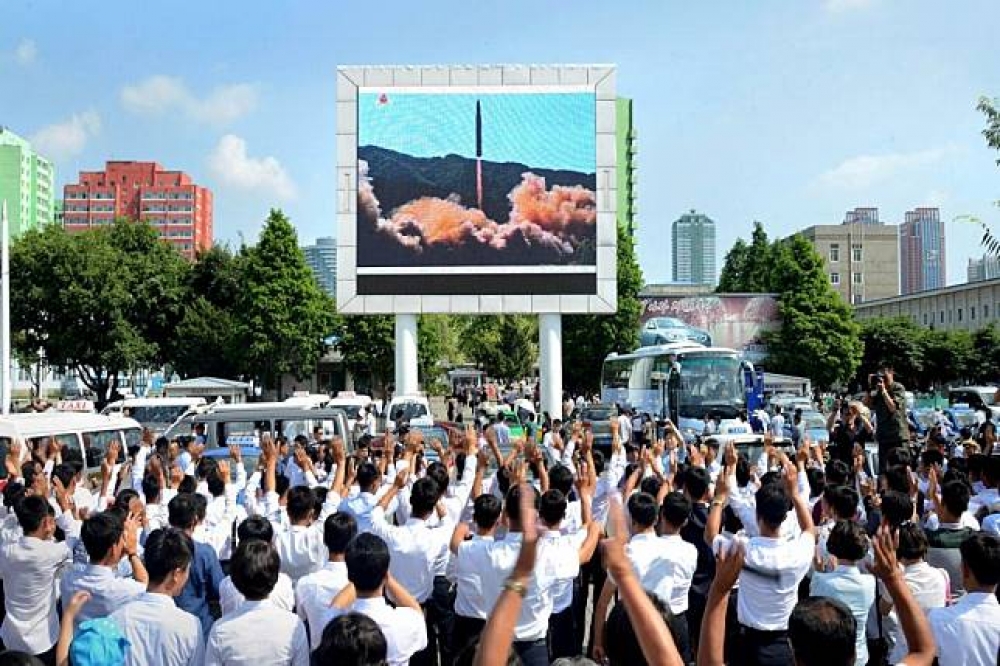 北韓政府釋出「火星-14型」彈道飛彈4日發射，北韓民眾歡欣鼓舞的畫面。（湯森路透）
