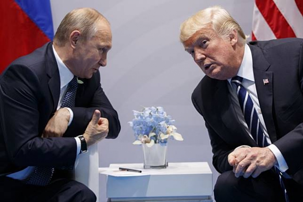 俄羅斯總統普京（左）、美國總統川普（右）藉德國漢堡G20峰會進行場邊會議。（美聯社）