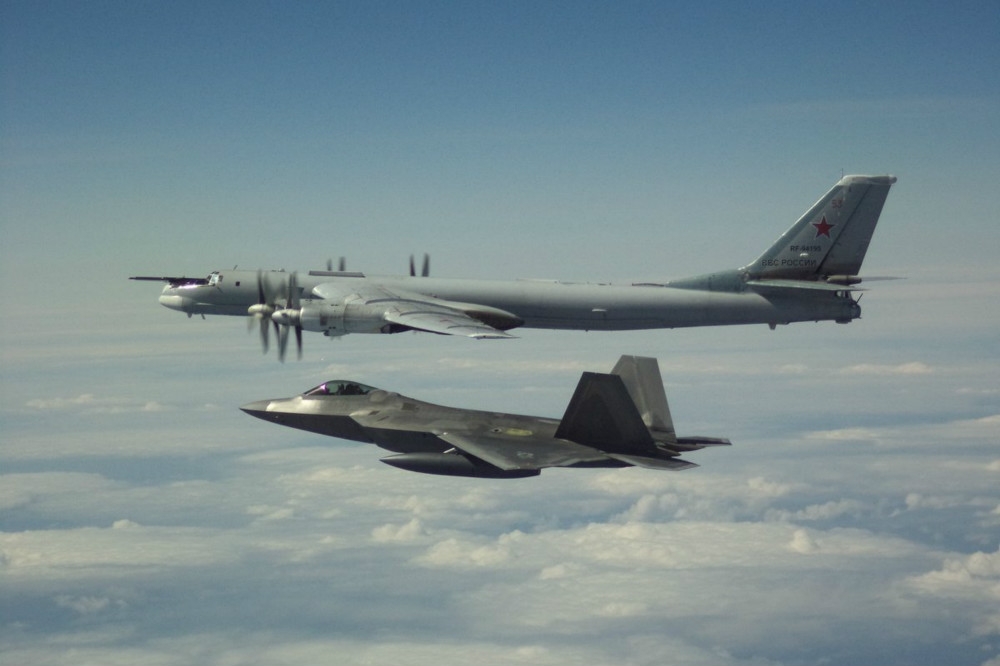 美軍F-22「猛禽」戰機（下）升空監視俄羅斯圖95轟炸機（上）。（圖片取自北美空防司令部）